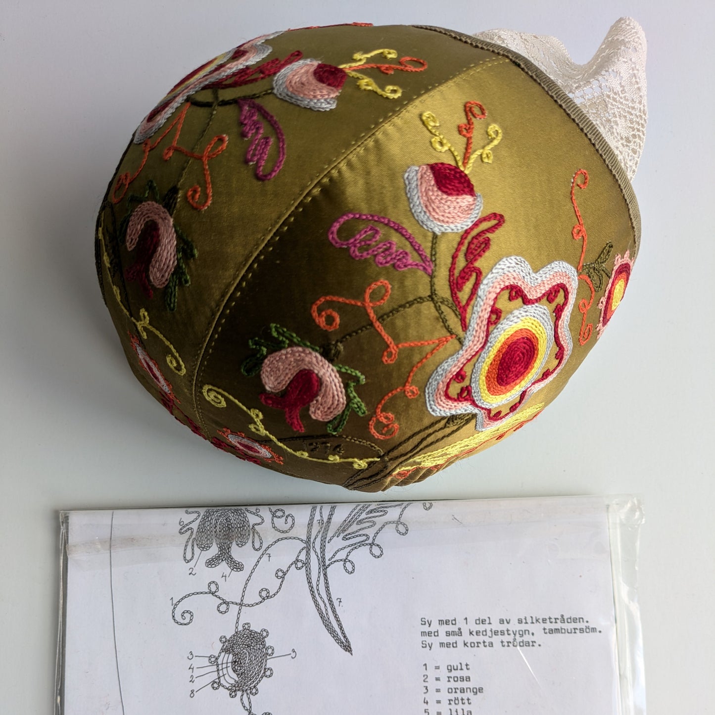 Kinda bindmössa broderisats med beskrivning